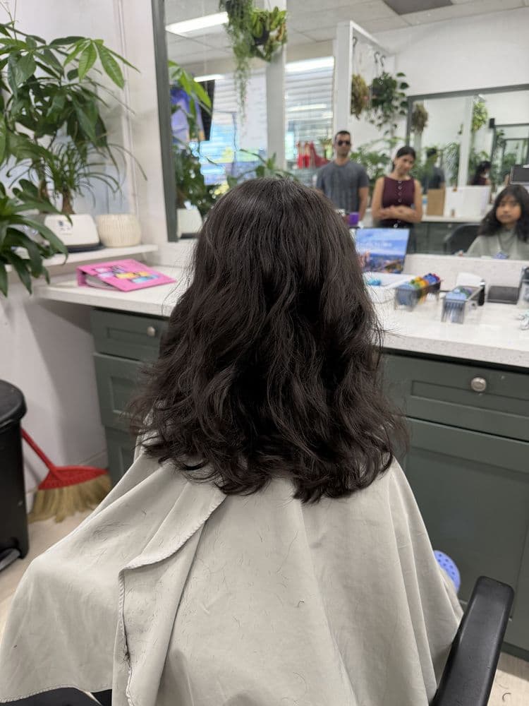 Women's dark wavy haircut shaped at Dimension Hair Salon in Bothell