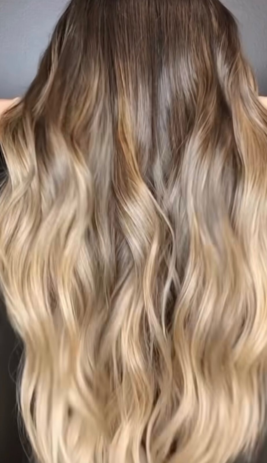 Long blonde balayage styled with loose waves