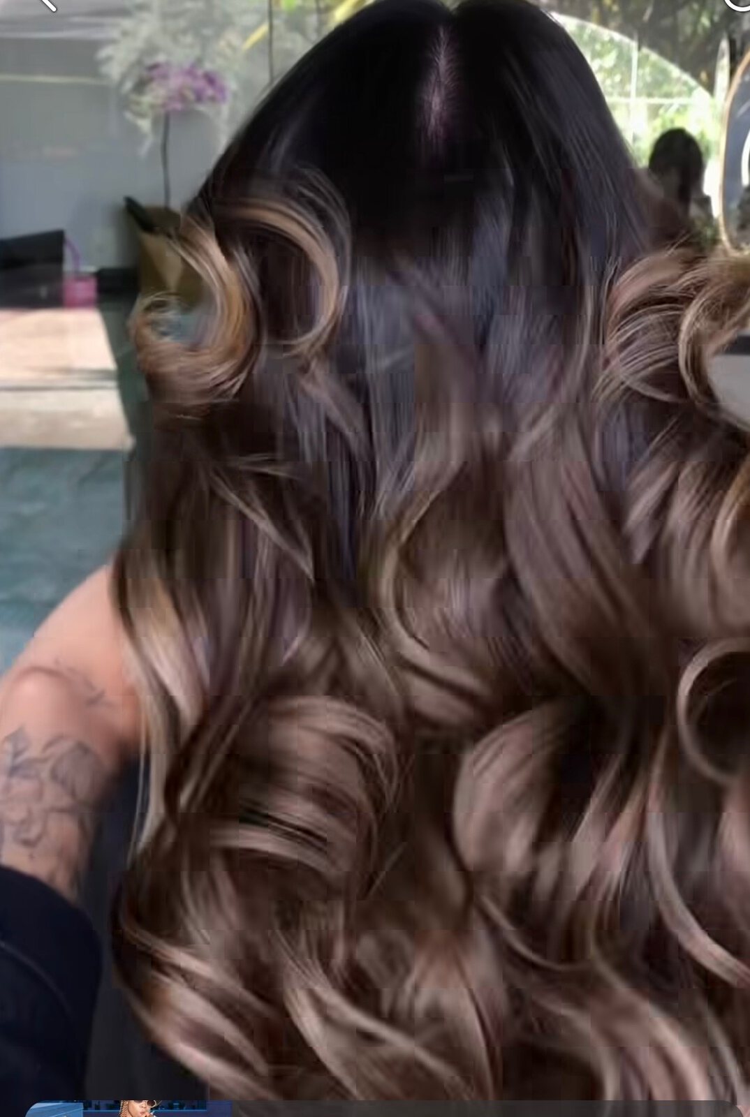 Glossy brunette hair styled in polished voluminous waves