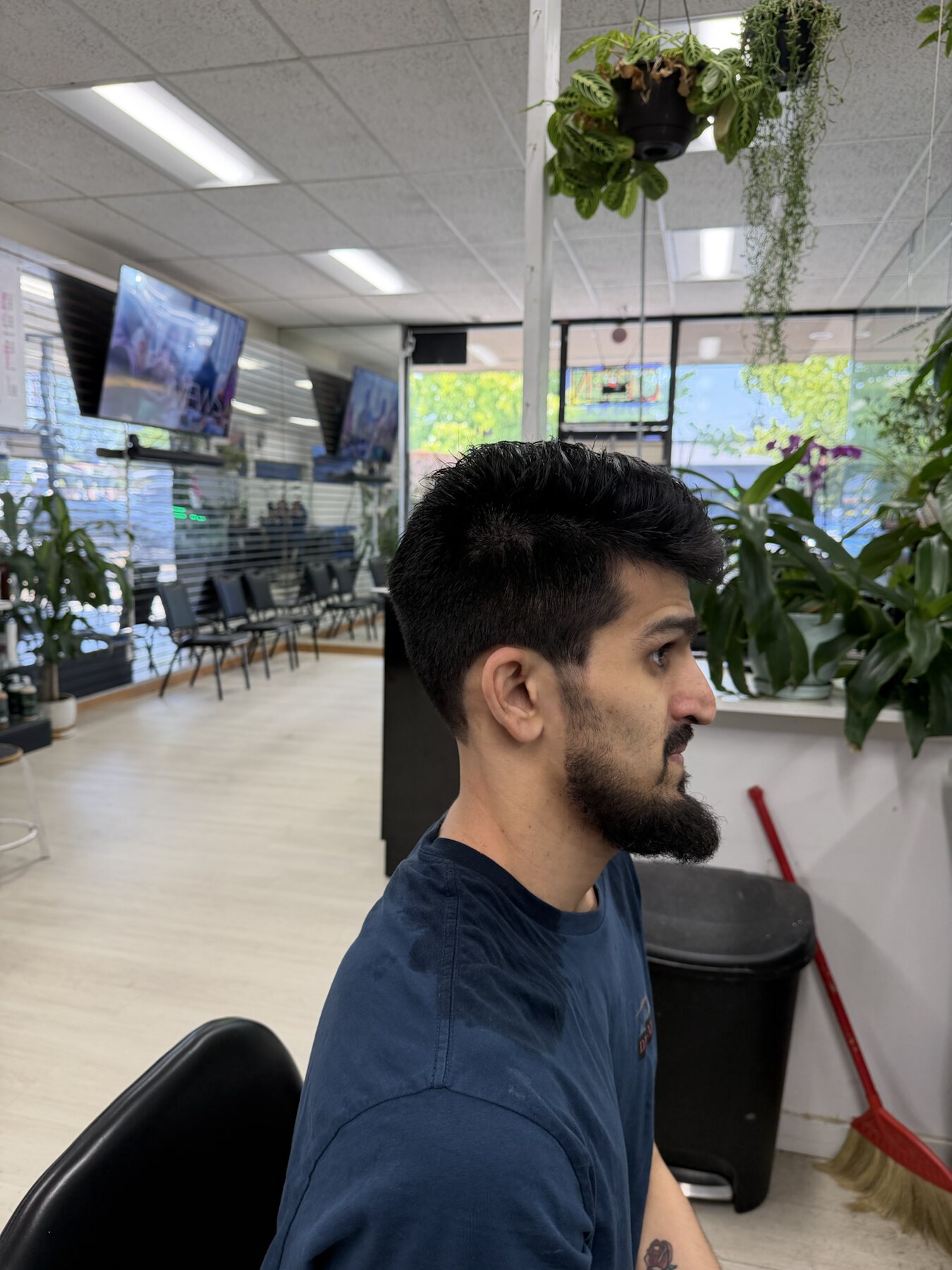 Men's curly short haircut and beard profile